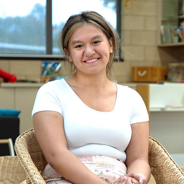 Young woman sitting on chair smiling