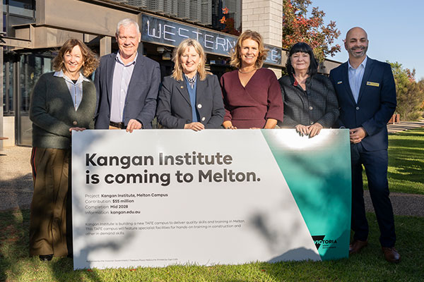 People holding sign outside Melton campus